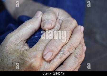 Mani aggrappate di vecchio Myanmar asiatico. Concetto di artrite reumatoide, osteoartrite o dolore articolare. Foto Stock