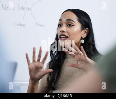 Questa presentazione sta andando così bene. Scatto di una giovane donna d'affari che dà una presentazione in ufficio. Foto Stock