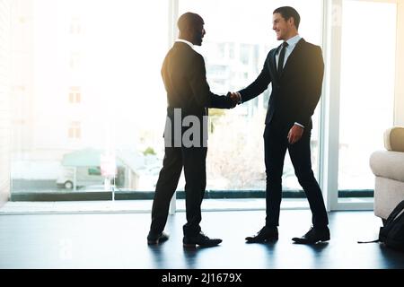 Creazione di nuove relazioni commerciali. Scatto completo di due uomini d'affari che scuotono le mani in un ufficio. Foto Stock