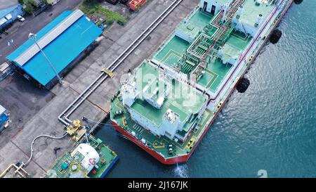 Unità di stoccaggio e rigassificazione galleggiante rossa e bianca, FSRU, nave GNL nel porto di Benoa sotto il cielo azzurro. Foto Stock