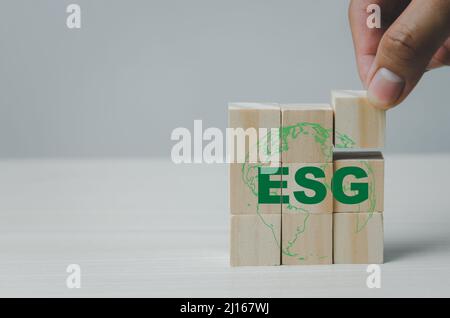 Mettere a mano cubi di legno con ESG Environmental Social Governance simbolo sul tavolo copia space.Business concetti. Foto Stock