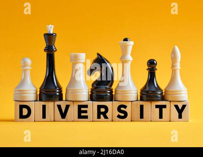 La diversità di parola su cubi di legno con varietà diversa di pezzi di scacchi. Strategia di diversità nel concetto di business. Foto Stock