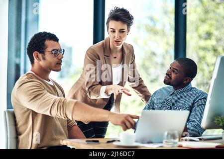 La tecnologia aiuta i team a collaborare per completare rapidamente i progetti. Scatto ritagliato di tre designer che hanno una sessione di brainstorming in ufficio. Foto Stock