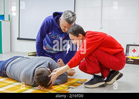 Non esclusiva: UZHHOROD, UCRAINA - 20 MARZO 2022 - un istruttore guida le azioni di un uomo durante un corso di pronto soccorso gratuito, Uzhhorod, Zakarpattia Re Foto Stock