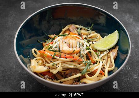 Spaghetti con frutti di mare su sfondo scuro. Gamberi, calamari Foto Stock