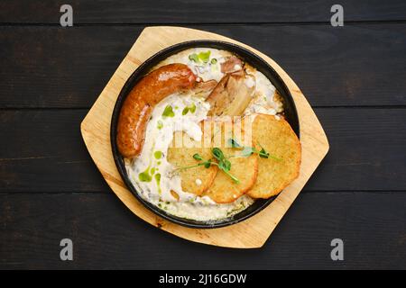 Vista dall'alto delle frittelle di patate con salsiccia tedesca fritta e fette di pancia di maiale Foto Stock