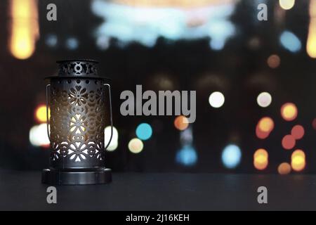 Lanterna, lampada a candela con sfondo luminoso bokeh città. Musulmano, mese santo di Ramadan Kareem. Foto Stock