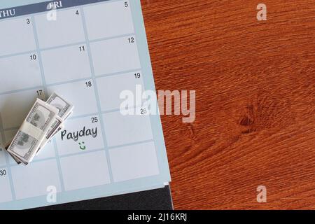 Immagine della vista dall'alto delle banconote e DEL GIORNO DI PAGA scritto su un calendario. Spazio di copia per il testo. Foto Stock