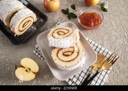 rotolo di frutta senza bottoni fatto in casa su un piatto rettangolare in ceramica grigia su un tovagliolo di stoffa. dessert delizioso, snack. sfondo grigio Foto Stock