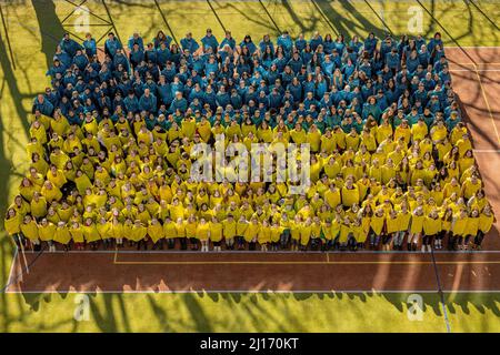 Liberec, Repubblica Ceca. 23rd Mar 2022. Gli alunni e i dipendenti della scuola elementare Hus di Liberec, Repubblica Ceca, hanno creato un'immagine dal vivo della bandiera Ucraina, il 23 marzo 2022, a Liberec. Tutti coloro che contribuiscono alla collezione destinata all'acquisto di forniture scolastiche per bambini ucraini che parteciperanno a soggiorni di adattamento presso le scuole Liberec riceveranno una fotografia della bandiera dal vivo. Credit: Radek Petrasek/CTK Photo/Alamy Live News Foto Stock