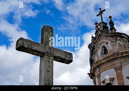 Croce e chiesa barocca sullo sfondo, Ouro Preto, Brasile Foto Stock