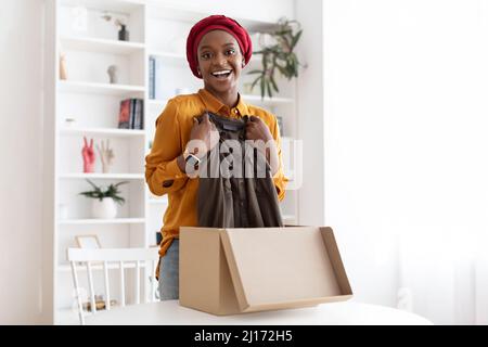 Felicissima donna afroamericana ha ricevuto il pacchetto dal negozio online Foto Stock