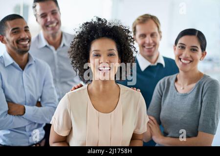 La positività porta alla produttività. Ritratto di un gruppo di colleghi diversi in ufficio. Foto Stock