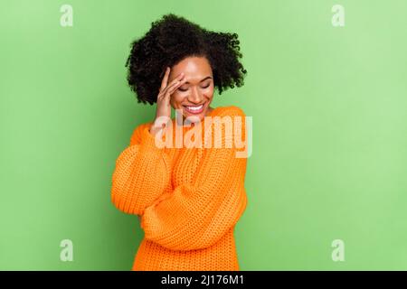 Foto di dolce millenario volume hairdo donna chiudi viso indossare arancione jumper isolato su sfondo verde Foto Stock