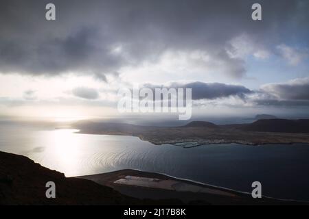 Nuvole sopra l'isola la Graciosa dal mare, Lanzarote, Spagna Foto Stock