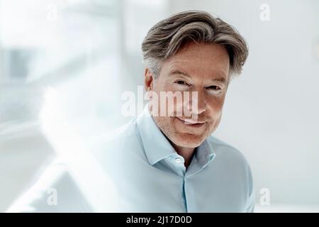 Uomo d'affari che indossa una camicia blu in ufficio Foto Stock
