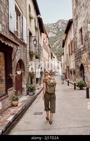 Donna con zaino a piedi nella città di Villefranche-de-Conflent Foto Stock