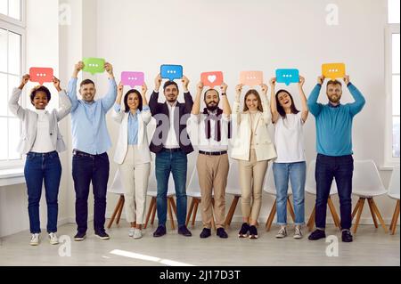 Gruppo vario di giovani uomini e donne felici che tengono colorate bolle messaggio chat Foto Stock