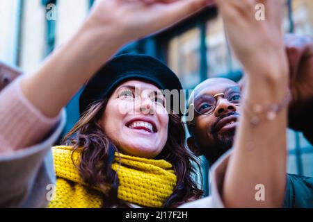 Coppia felice tenendo selfie in città Foto Stock