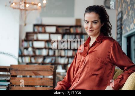 Donna sorridente in seduta cafe Foto Stock