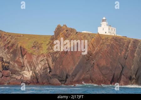 Vista del faro sull'isola di Skokholm dal mare, Pembrokeshire, Galles, Regno Unito, Europa Foto Stock