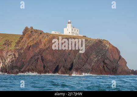 Vista del faro sull'isola di Skokholm dal mare, Pembrokeshire, Galles, Regno Unito, Europa Foto Stock