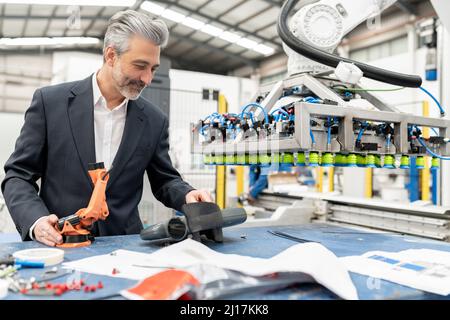Ingegnere che lavora con le parti della macchina in fabbrica Foto Stock