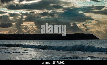 Foto a colori del mare da Penbryn Beach guardando verso le pesanti nuvole di tempesta che si raccolgono sul promontorio di Aberporth in Cardigan Bay West Wales Foto Stock