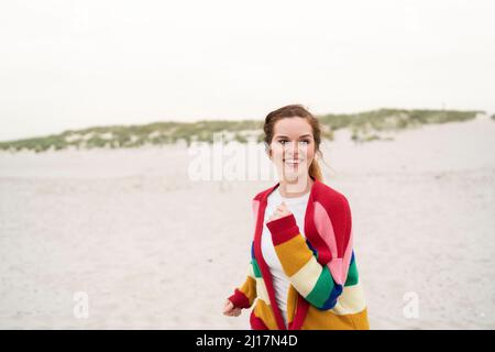 Felice giovane donna che indossa un maglione cardigan godendo il fine settimana Foto Stock