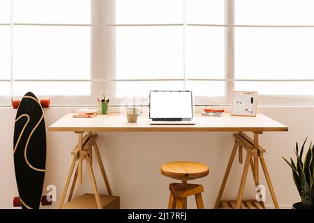 Laptop sul tavolo davanti alla finestra a casa Foto Stock