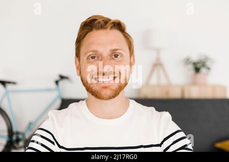 Buon giovane uomo con capelli rossi a casa Foto Stock