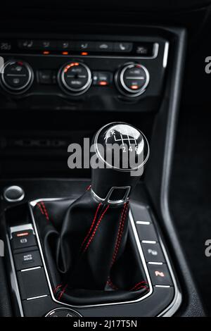 Interno dell'auto. La leva del cambio manuale nella cabina dell'auto è in primo piano. Stile scuro. Sfondo Foto Stock