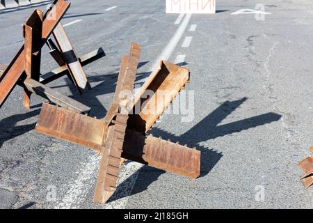 Guerra della Russia contro l'Ucraina. Strutture metalliche anticarro sulle strade di Kyiv. Riccio antitank sulla carreggiata di una strada cittadina in una giornata di sole. Foto Stock