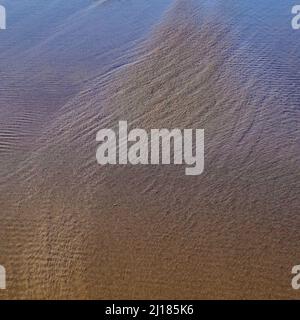 Abstract dettagliati schemi di marea in sabbia a bassa marea in Penbryn Beach in South West Wales UK Foto Stock