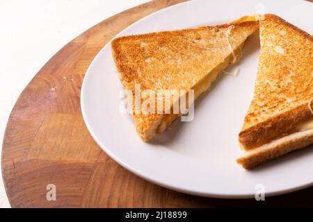 Vista ravvicinata ad angolo alto del sandwich di formaggio fresco servito in piatto su un tavolo di legno Foto Stock