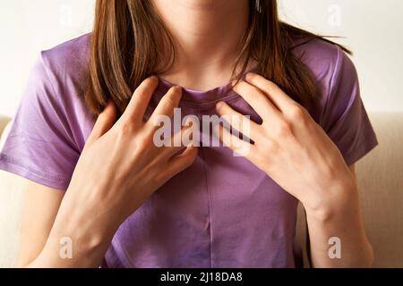 Ragazza adolescente che pratica EFT o la tecnica di libertà emotiva - toccando il punto del collarbone Foto Stock