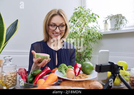 Donna che racconta e mostra cibo sano, frutta verdura frutta frutta uova cereali Foto Stock