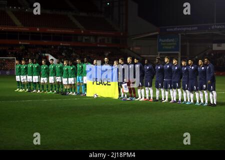 I giocatori dell'Inghilterra e della Repubblica d'Irlanda detengono una bandiera a sostegno dell'Ucraina prima della partita del campionato europeo Under-19 della UEFA del 2022 al Banks's Stadium di Walsall. Data foto: Mercoledì 23 marzo 2022. Foto Stock