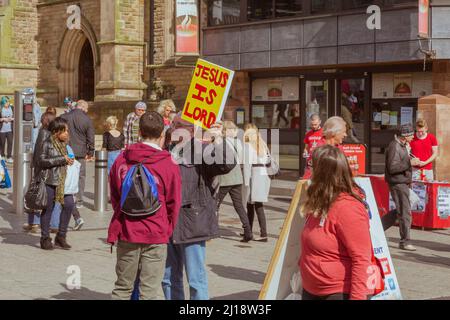 Un predicatore di strada tiene un cartello che dice Jesus is Lord in una zona trafficata dello shopping del centro della città. Foto Stock