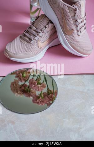 Kiev, Ucraina - 13 luglio 2020: Scarpe da running Nike con specchio e fiori rosa garofano Foto Stock