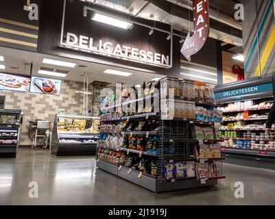 Kirkland, WA USA - circa Febbraio 2022: Vista di una zona di delicatessen all'interno di un negozio di alimentari QFC, che espone patatine, paste spalmabili e formaggi. Foto Stock