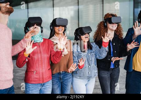 I giovani che indossano occhiali virtuali all'aperto - concetto metaverse - Focus sul volto della ragazza con giacca jean Foto Stock