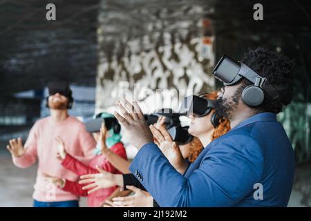 I giovani che indossano occhiali virtuali all'aperto - Metaverse Concept - Focus on african man headset Foto Stock