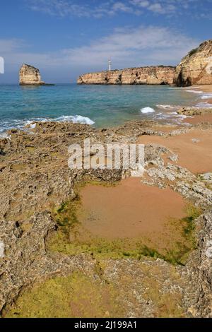 Praia dos Caneiros Spiaggia-mare stack, faro e scogliere sfondo. Ferragudo-Portogallo-172 Foto Stock