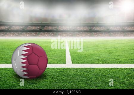 Calcio in uno stadio all'aperto luminoso con bandiera Qatar dipinta. Focus su primo piano e palla di calcio con profondità di campo poco profonda sullo sfondo e co Foto Stock