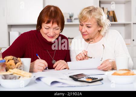 Donne anziane allegre con documenti Foto Stock