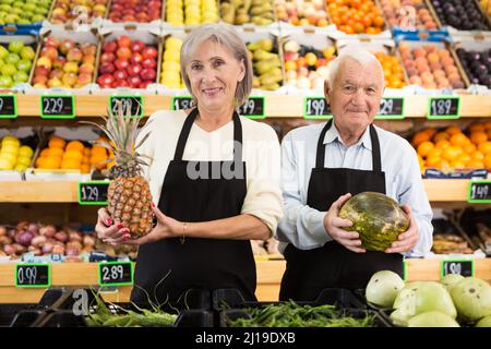 Lavoratori maturi di supermercati in piedi in sala di vendita Foto Stock