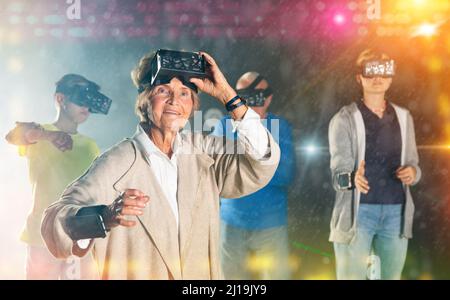 Nonna stupita in VR club con la famiglia Foto Stock