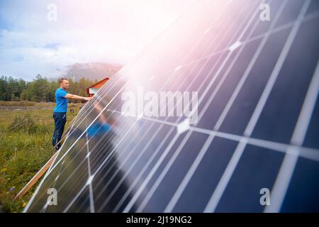 Giovane ingegnere maschio installazione e funzionamento pannelli solari. Concetto di preparazione degli elementi elettrici energetici per l'inverno. Foto Stock