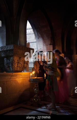 I credenti illuminano una candela alla Cappella Greco Ortodossa all'interno della Chiesa Crociata all'interno delle mura dell'antica Gerusalemme, Isreale, Medio Oriente, Asia Foto Stock